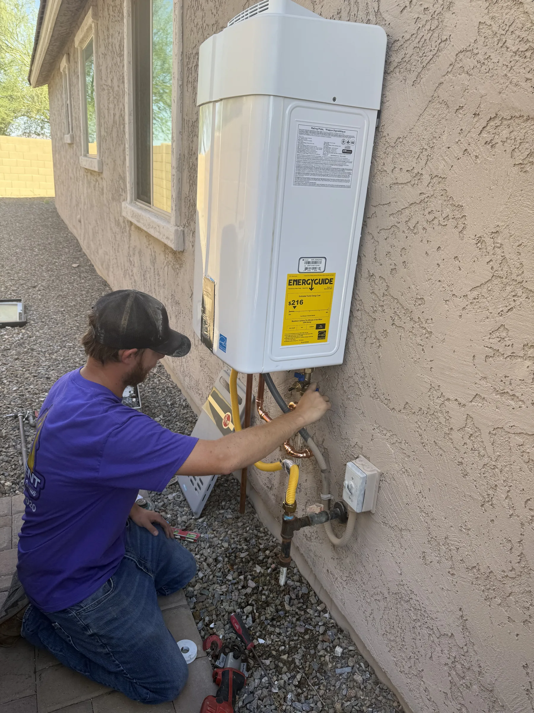 Trident Plumbing technician installing a tankless water heater